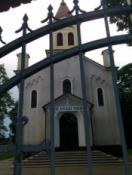 Kościół w Pławnie widok przez kraty bramy głównej